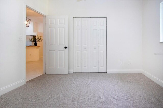 unfurnished bedroom featuring a closet, carpet flooring, and baseboards