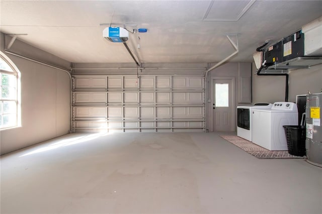 garage with a garage door opener, washing machine and dryer, and electric water heater