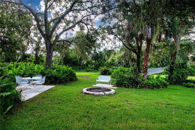 view of yard featuring an outdoor fire pit and a patio