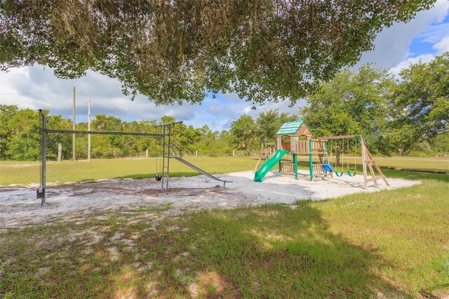 view of jungle gym featuring a lawn