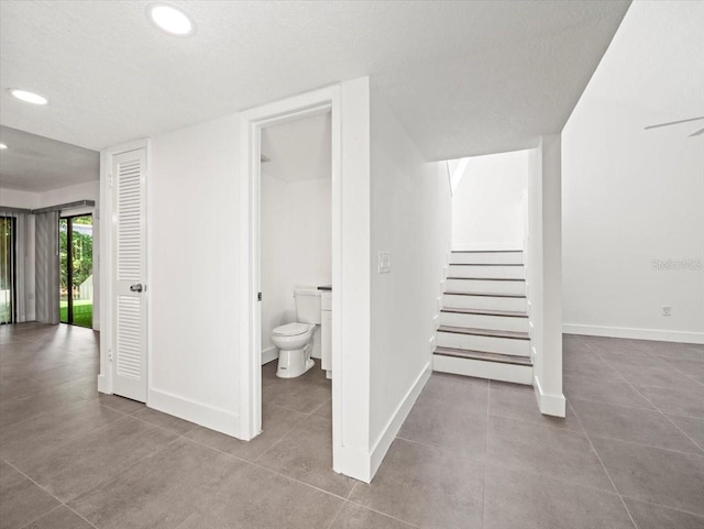 interior space with a textured ceiling and tile patterned floors