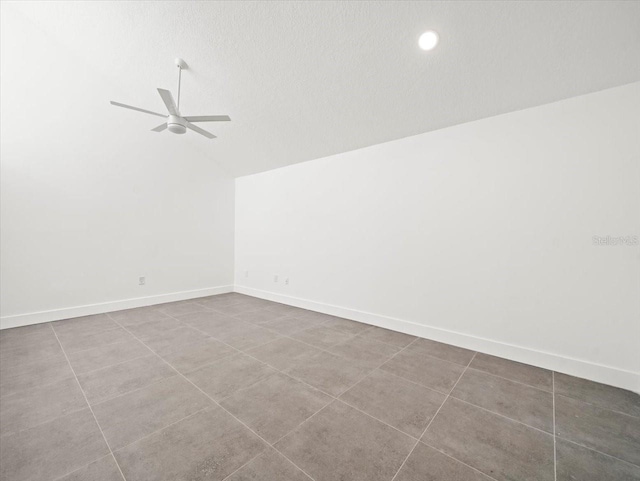 empty room with tile patterned floors, ceiling fan, a textured ceiling, and vaulted ceiling