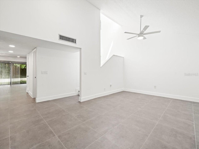 tiled empty room featuring a textured ceiling, high vaulted ceiling, and ceiling fan