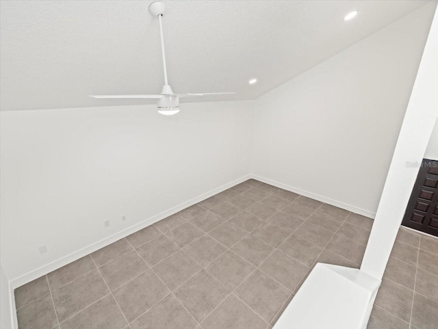 tiled empty room with vaulted ceiling and ceiling fan