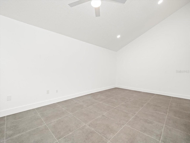 tiled empty room featuring ceiling fan and vaulted ceiling