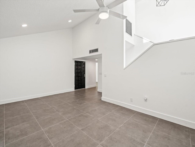 spare room featuring tile patterned floors, high vaulted ceiling, a textured ceiling, and ceiling fan