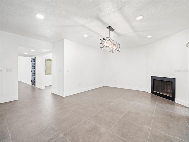 unfurnished living room featuring a textured ceiling and tile patterned floors