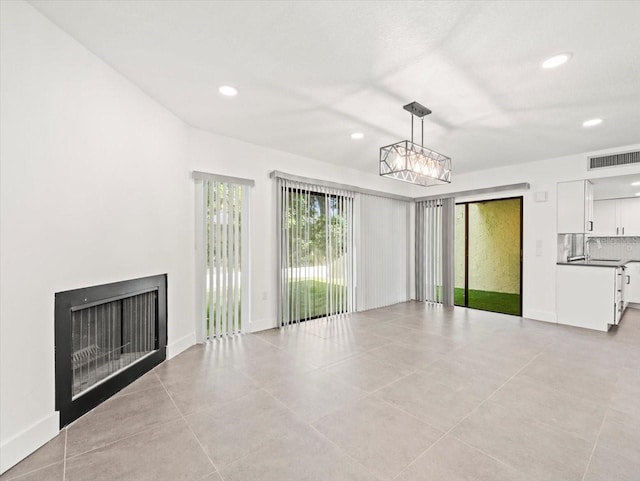 interior space featuring an inviting chandelier, light tile patterned floors, and sink