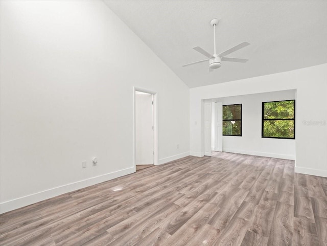 unfurnished room with high vaulted ceiling, ceiling fan, and light hardwood / wood-style flooring