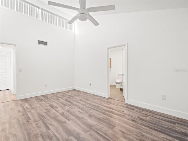 interior space with ensuite bathroom, wood-type flooring, high vaulted ceiling, and ceiling fan