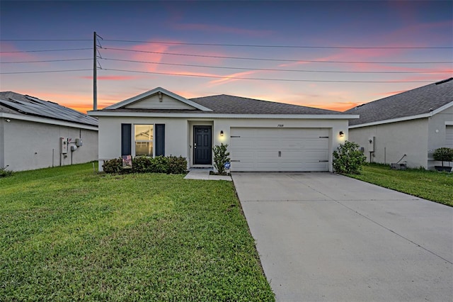 ranch-style home with a garage and a yard