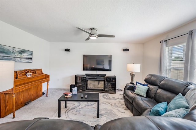 carpeted living room with a fireplace, ceiling fan, and a textured ceiling