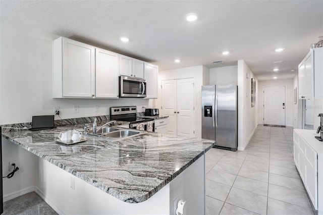 kitchen featuring sink, white cabinetry, stone countertops, and stainless steel appliances