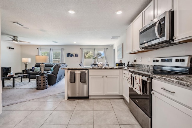 kitchen with light tile patterned floors, sink, ceiling fan, white cabinetry, and stainless steel appliances