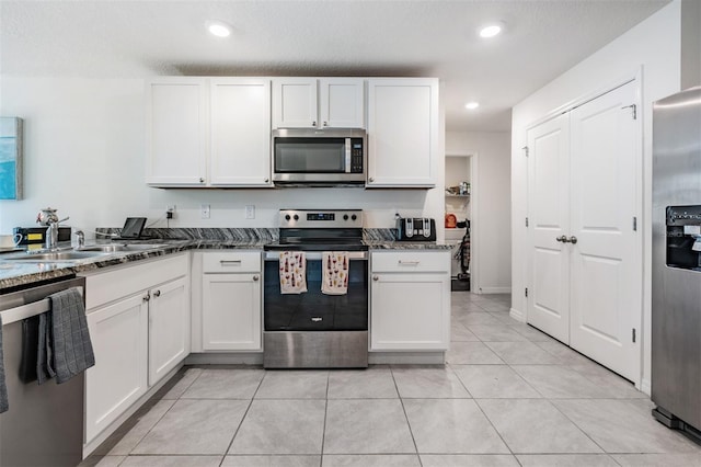 kitchen with white cabinetry, appliances with stainless steel finishes, and light tile patterned floors