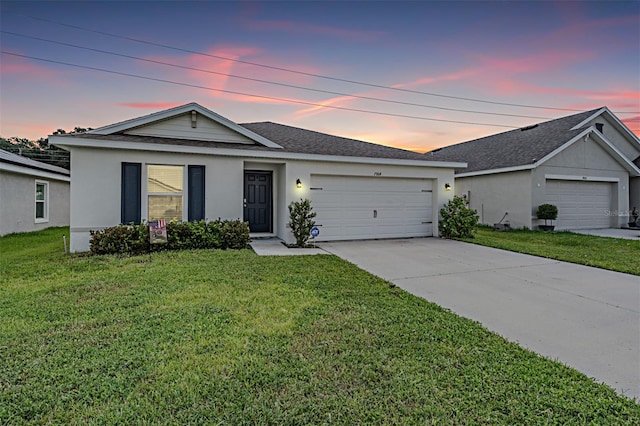 ranch-style house featuring a lawn and a garage