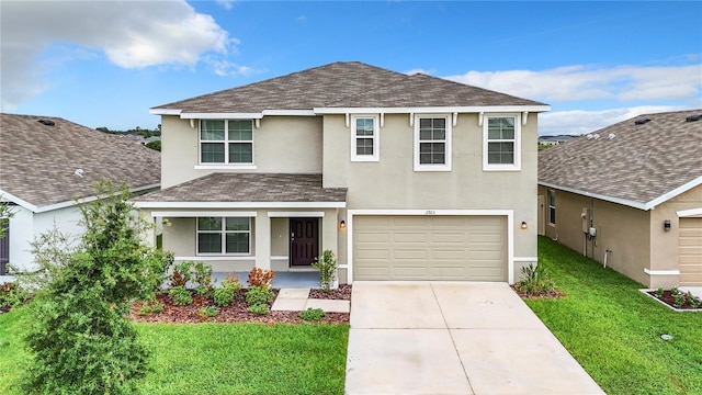 traditional home with a front yard, concrete driveway, roof with shingles, and stucco siding