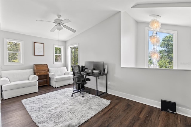 office area featuring ceiling fan with notable chandelier, dark wood-type flooring, and vaulted ceiling