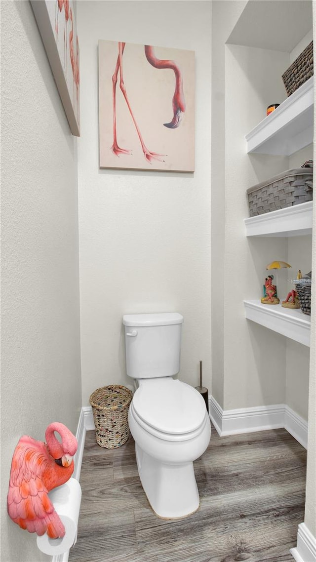 bathroom with hardwood / wood-style flooring and toilet