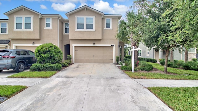 multi unit property featuring a garage, concrete driveway, and stucco siding