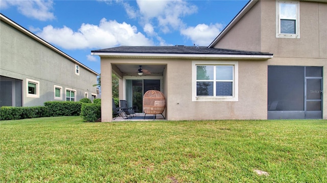 property entrance with a yard, ceiling fan, and stucco siding