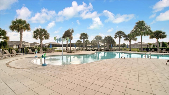 pool with a patio and fence