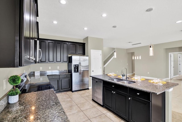 kitchen with light stone countertops, sink, a center island with sink, light tile patterned flooring, and stainless steel appliances