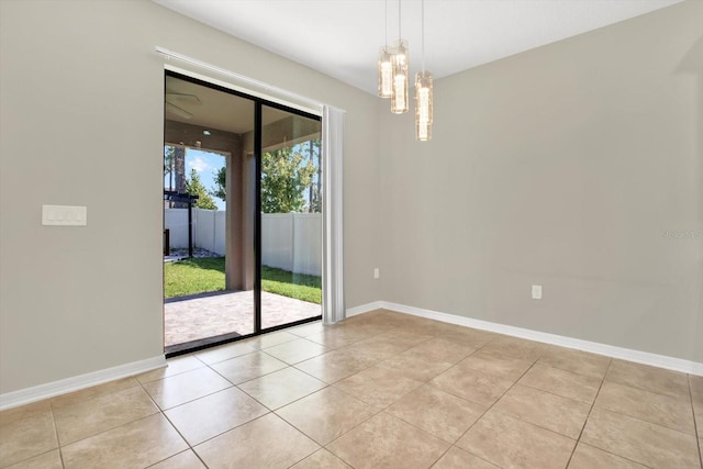 tiled empty room featuring a notable chandelier