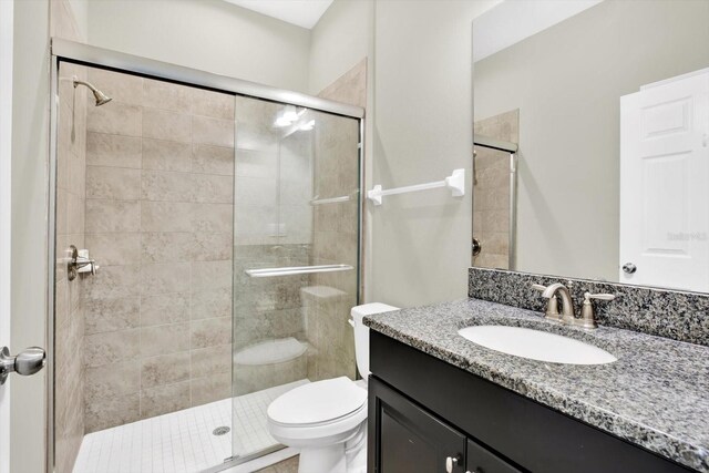 bathroom with toilet, vanity, and walk in shower