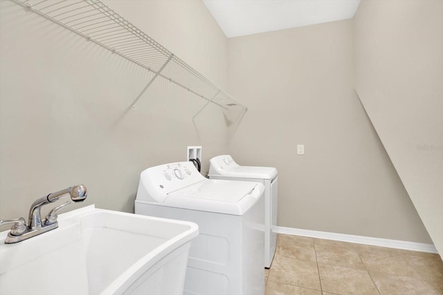 laundry area featuring light tile patterned floors, sink, and washing machine and clothes dryer