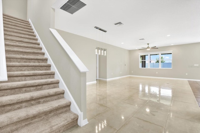 stairway with ceiling fan and tile patterned flooring