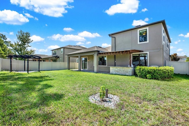 back of property featuring a yard and a pergola