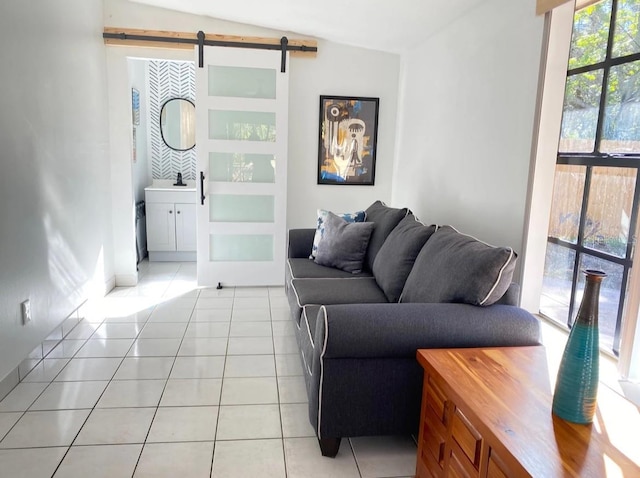 tiled living room featuring sink, lofted ceiling, and a barn door