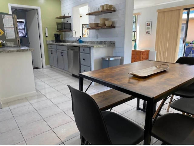 tiled dining room featuring a wealth of natural light and sink