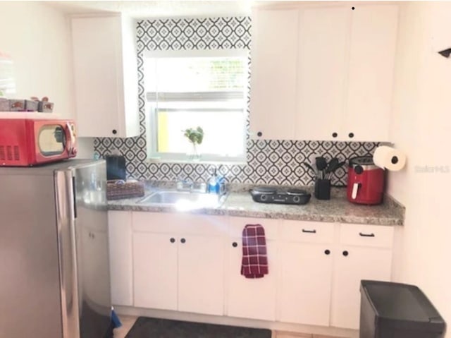 kitchen featuring appliances with stainless steel finishes, sink, decorative backsplash, and white cabinets