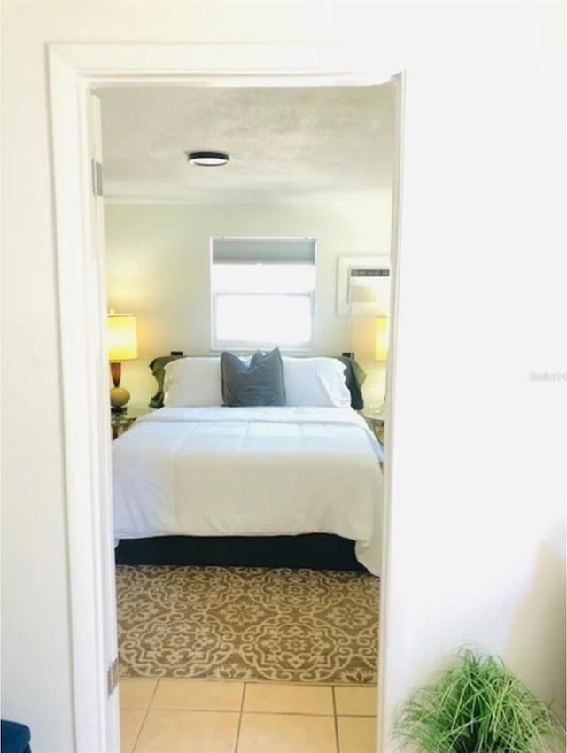 bedroom with a wall unit AC and light tile patterned flooring