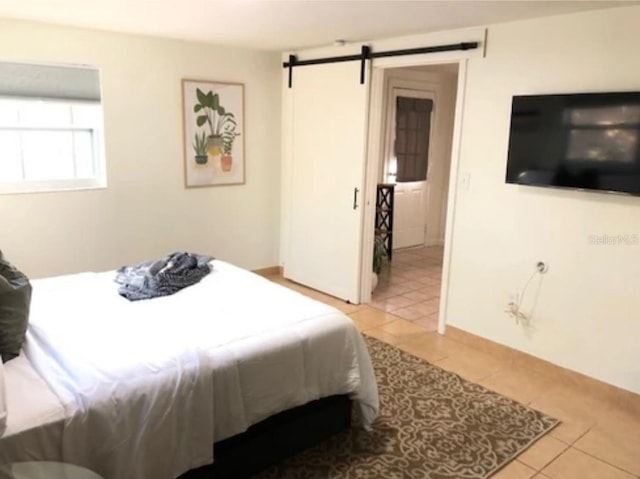 bedroom featuring light tile patterned floors and a barn door