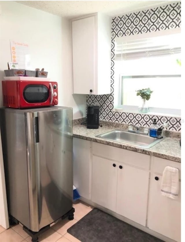 kitchen with white cabinetry, backsplash, sink, and stainless steel appliances