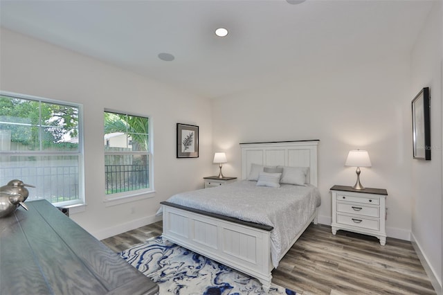 bedroom featuring multiple windows and dark hardwood / wood-style floors