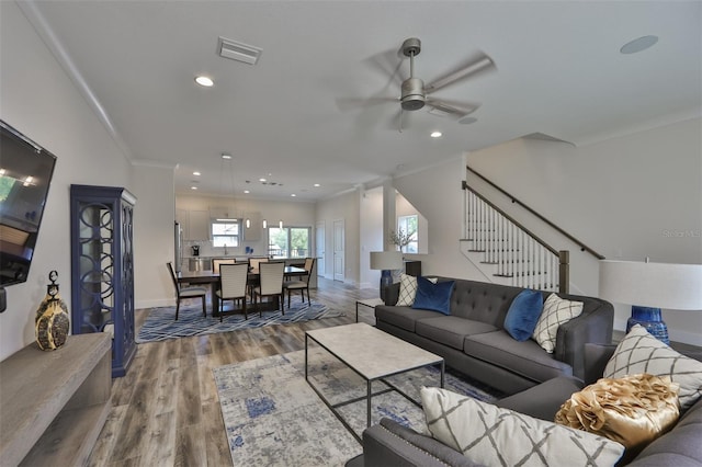 living room featuring ceiling fan, ornamental molding, and hardwood / wood-style flooring