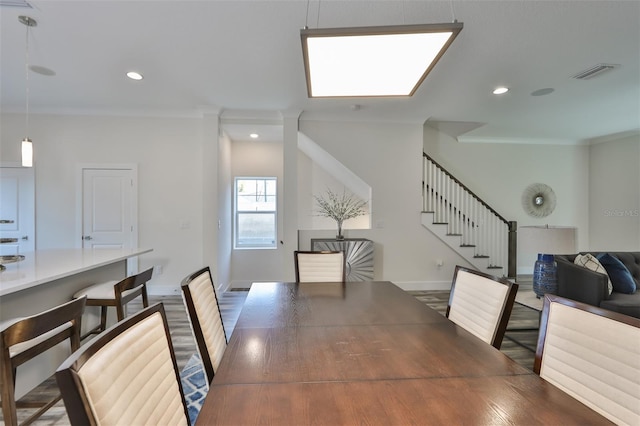 dining space with hardwood / wood-style flooring and ornamental molding