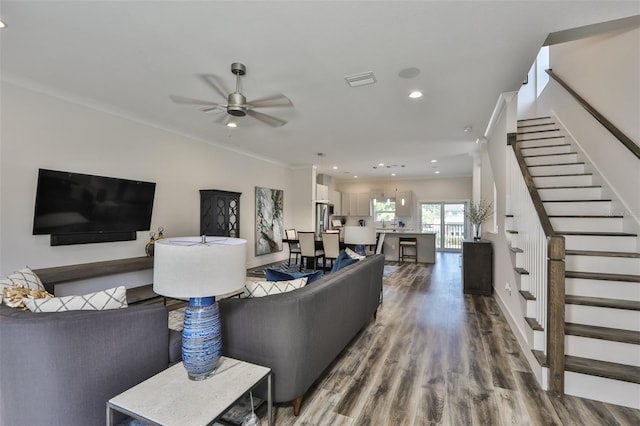 living room featuring ceiling fan, crown molding, and wood-type flooring