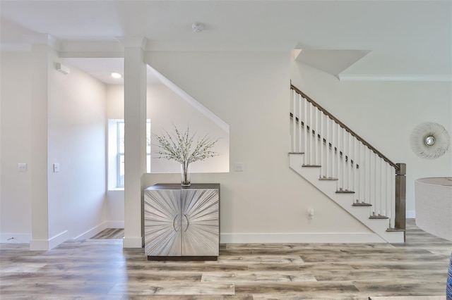 stairway featuring crown molding and wood-type flooring