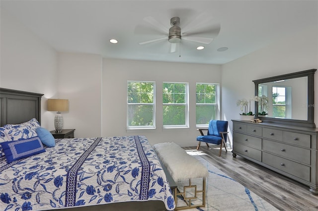 bedroom with multiple windows, light hardwood / wood-style flooring, and ceiling fan