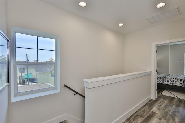 hall with dark wood-type flooring and a healthy amount of sunlight