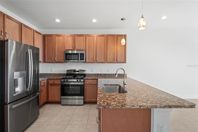 kitchen with sink, appliances with stainless steel finishes, pendant lighting, and light tile patterned floors