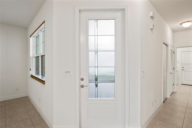 entryway with light tile patterned floors and baseboards