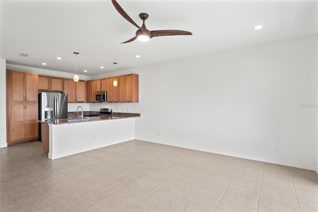 kitchen featuring dark stone counters, light tile patterned floors, decorative light fixtures, ceiling fan, and stainless steel appliances