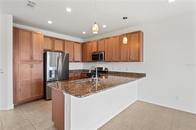 kitchen with dark stone counters, pendant lighting, light tile patterned floors, kitchen peninsula, and stainless steel appliances