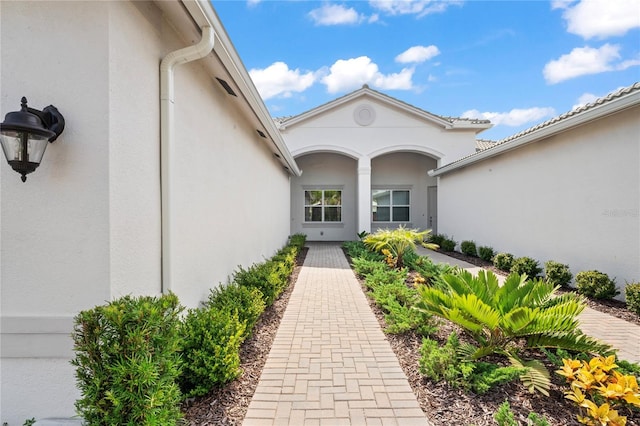 doorway to property featuring stucco siding